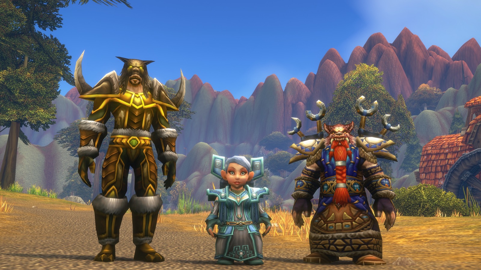 A tauren, a gnome and a dwarf in ornate armour standing together on a sunny hillside with mountains behind