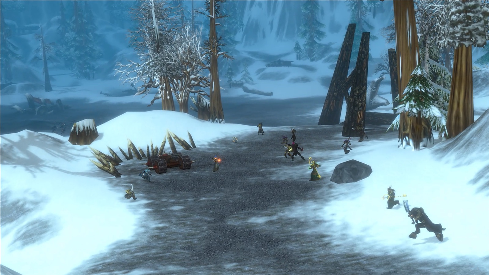 In-game screenshot: small groups of players fighting across a snowy road between pine trees and wooden spikes